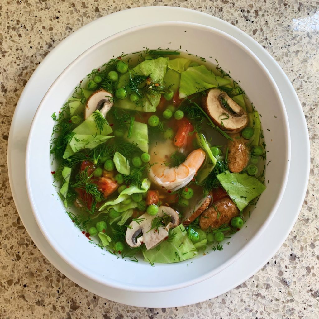 Easy healthy food pescatarian shrimp recipe for homemade Thai om curry soup with fresh vegetables peas cabbage mushrooms tomato fish sauce lime peas dill herbs light lunch dinner cooking